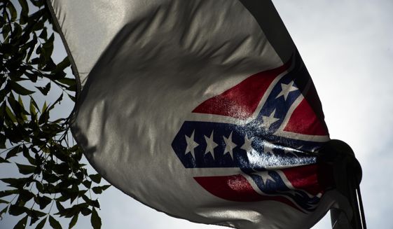 A Confederate flag flies next to the Alabama Confederate Memorial on the grounds of the Alabama Capitol building in Montgomery, Ala., Monday, June 22, 2015. (Albert Cesare/The Montgomery Advertiser via AP) NO SALES; MANDATORY CREDIT